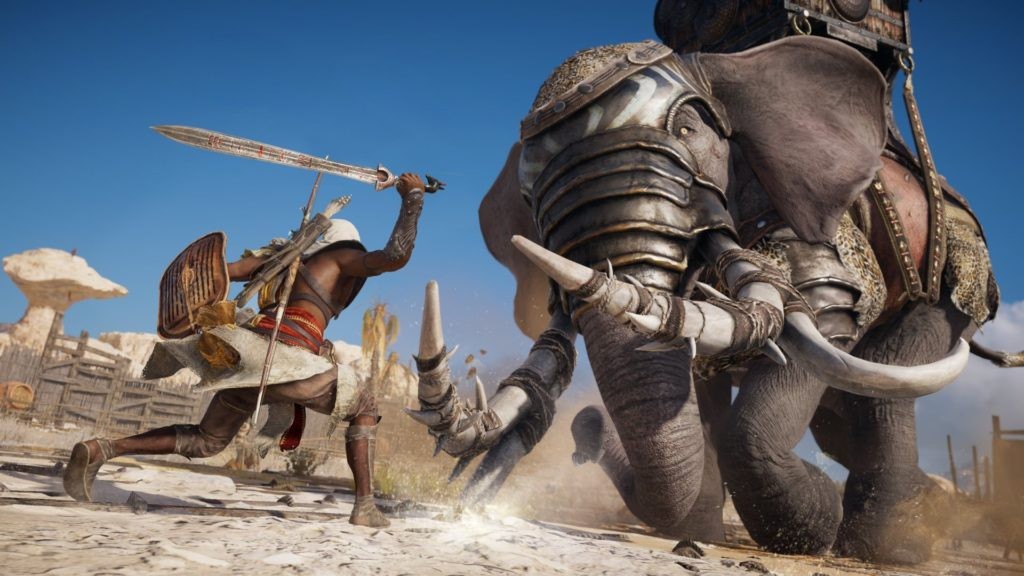 Image Description: Assassin's Creed: Origins - Bayek fighting an elephant in a desert arena. End of Image Description.
